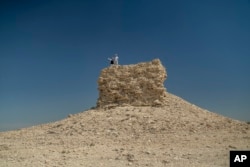 A couple visits a devastated village and areas near the dried-up Aral Sea, outside Muynak, Uzbekistan, June 24, 2023.