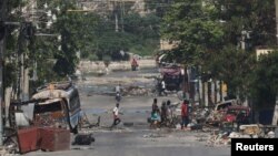 FILE - Armed gang members walk through the streets in Port-au-Prince, Haiti, April 23, 2024. Months of gang violence in Haiti have forced the government into retreat, and U.S. officials warn the country is close to becoming a failed state. 