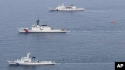 2024年6月6日，日本海上保安厅提供的这张照片显示，日本海上保安厅的巡逻舰“若狭号”（自下而上）、美国海岸警卫队的巡逻舰“韦舍山号”和韩国海洋警察厅的巡逻舰“泰平壤 16 号”以及一架飞行中的直升机（红色）在日本舞鹤北部海岸附近海域参加演习。（美联社照片）