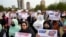 FILE - Afghan refugees hold placards during a rally protesting U.S. visa processing delays, in Islamabad, Pakistan, Feb. 26, 2023.
