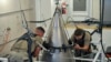FILE - Senior Airman Jacob Deas and Airman 1st Class Jonathan Marrs secure the titanium shroud at the top of a Minuteman III intercontinental ballistic missile on Aug. 24, 2023, at the Bravo 9 silo at Malmstrom Air Force Base in Montana.