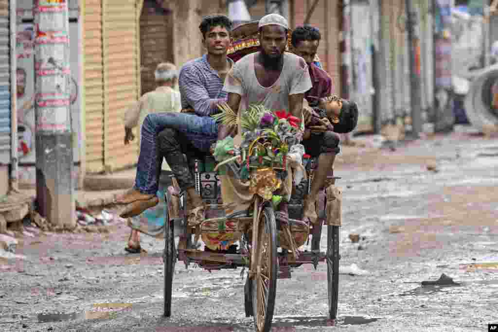People carry an injured protester in a cycle rickshaw to a hospital after he was shot at by the police during a protest against Prime Minister Sheikh Hasina and her government, in Dhaka, Aug. 5, 2024.