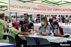 Convention attendees verify proof of COVID-19 vaccination and/or negative tests outside the San Diego Convention Center at Comic-Con International, in California, July 21, 2022.