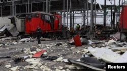 A police officer walks among debris at a site of a postal distribution center of Nova Post company hit by Russian missiles in the village of Korotych, outside of Kharkiv, Ukraine, Oct. 22, 2023. 