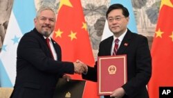 에두아르도 엔리케 레이나(왼쪽) 온두라스 외무장관과 친강 중국 외교부장 겸 국무위원이 26일 베이징에서 외교관계 수립에 관한 공동성명에 서명한 뒤 악수하고 있다. 