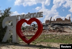 Sebuah penanda kota "Saya Cinta Hulyaipole' tampak di dekat gedung yang hancur akibat serangan militer Rusia di Hulyaipole, wilayah Zaporizhzhia, Ukraina, 3 September 2023. (Foto: Oleksandr Ratushniak/Reuters)