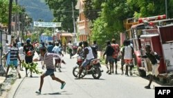 Des personnes fuient les gaz lacrymogènes alors qu'elles manifestent contre la hausse du coût de la vie à Petit-Goâve, en Haïti, le 14 septembre 2023. (Photo Richard PIERRIN / AFP)