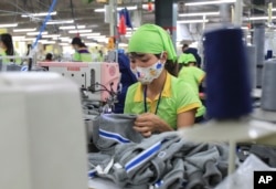 រូបឯកសារ៖ កម្មករម្នាក់កំពុងដេរសម្លៀកបំពាក់នៅក្នុងរោងចក្រ Pro Sports ក្នុងខេត្ត Nam Dinh ប្រទេសវៀតណាម កាលពីថ្ងៃទី២៤ ខែតុលា ឆ្នាំ២០១៧។