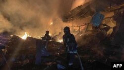 This handout photograph taken and released by Ukrainian Emergency Service on August 14, 2023, shows rescuers pushing out a fire in a supermarket after a night strike in Odesa on Aug. 14, 2023. (Photo by Handout / Ukrainian Emergency Service / AFP)