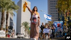 Një grua mban fotografinë e një fëmije të rrëmbyer gjatë sulmit të Hamasit në Israel (Tel Aviv, 25 tetor 2023)