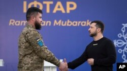 2023 年4月7日，在乌克兰基辅郊外的一个伊斯兰中心举行的庆祝伊斯兰斋月的开斋晚宴前，乌克兰总统泽连斯基（右）向一名穆斯林军人颁奖。