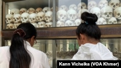 ស្រ្តីពីរ​នាក់​កំពុង​ឈរមើល​លលាដ៍ក្បាល​ជនរងគ្រោះ​នៅ​សារមន្ទីរជើង​ឯក​ក្នុង​ខណ្ឌដង្កោ​រាជធានី​ភ្នំពេញ (កាន់ វិច្ឆិកា/វីអូអេ)