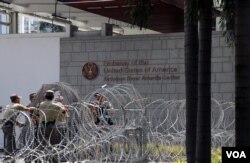 Pagar kawat berduri dipasang oleh petugas keamanan di depan Kedutaan Besar Amerika Serikat pada Rabu (11/10) di Jakarta untuk mengantisipasi masuknya massa yang berunjuk rasa di depannya. (VOA/Indra Yoga)