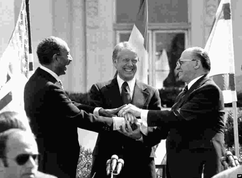 (from left to right) Egyptian President Anwar Sadat, U.S. President Jimmy Carter and Israeli Prime Minister Menachem Begin clasp hands on the north lawn of the White House in Washington, after signing the peace treaty between Egypt and Israel, March 26, 1979.