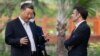 FILE - Chinese President Xi Jinping (L) and French President Emmanuel Macron (R) speak as they visit the garden of the residence of the Governor of Guangdong in Guangzhou, China, on April 7, 2023.