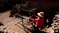 Teófila Challapa weaves on her loom at home in Cariquima, Chile, on July 31, 2023. Challapa, 59, prays before beginning her work: “Mother Earth, give me strength, because you're the one who will produce, not me." (AP Photo/Ignacio Munoz)