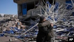 Syrian men comfort each other in Kahramanmaras, Turkey, Feb. 15, 2023.