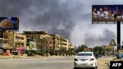 Asap mengepul di sepanjang jalan sepi di Khartoum pada 16 April 2023, saat berkecamuknya pertempuran antara kekuatan 2 jenderal yang bersaing. (Foto: AFP)