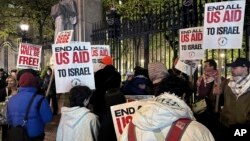 Pro-Palestinian protesters demonstrate outside the main gate at Columbia University, in New York, early April 26, 2024.