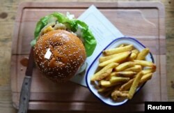 เมนู Swift burger ของร้าน The Black Dog ที่เจ้าของร้านเชื่อว่าถูกกล่าวถึงในเพลง The Black Dog ของเทย์เลอร์ สวิฟต์ ในกรุงลอนดอน อังกฤษ เมื่อ 22 เม.ย. 2024 (REUTERS/Toby Melville)