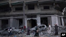 Palestinians walk amid the rubble following Israeli airstrikes that razed swaths of a neighborhood in Gaza City, Oct. 10, 2023.