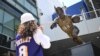 Des personnes regardent la statue de Jerry West, Los Angeles, le 12 juin 2024. 