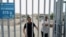FILE - This picture taken on July 19, 2023, shows men at the gates of a Uyghur cemetery in Yengisar in northwest China's Xinjiang region.