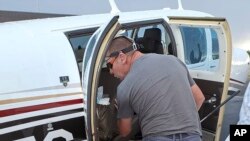 Afisa wa zimamoto akimsaka nyoka mwenye sumu kali ndani ya ndege, huko Welkom, Afrika Kusini, tarehe 3 Aprili, 2023. Picha na Brian Emmenis /AP.