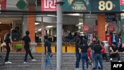 បុគ្គលិក​ហាង​ទំនើប​មួយ​កន្លែង​រង់ចាំ​នៅ​ក្រៅ​អគារ​នៅ​ទី​ក្រុង Denpasar នៃ​កោះ​ទេសចរណ៍​កម្សាន្ត បាលី (Bali) ប្រទេស​ឥណ្ឌូណេស៊ី កាល​ពី​ថ្ងៃ​ទី​១៤ ខែ​មេសា ឆ្នាំ​២០២៣ ក្រោយ​ពី​មាន​ការ​រញ្ជួយ​ផែនដី​កម្រិត​៧​រិចទ័រ។