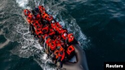 FILE - In this drone view an inflatable dinghy carrying migrants makes its way towards England in the English Channel, Britain, May 4, 2024. 