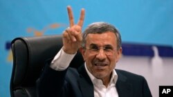 Iran's former President Mahmoud Ahmadinejad flashes a victory sign as he registers his name as a candidate for the June 28 presidential election at the Interior Ministry, in Tehran, Iran, June 2, 2024. 