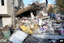 Palestinians search for the bodies of the Darwesh family killed in the Israeli bombardment of the Gaza Strip in Nusseirat refugee camp, central Gaza Strip, Jan. 2, 2024.