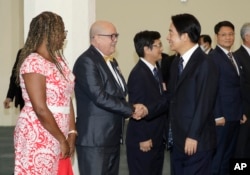 Taiwanese Vice President William Lai, right, shakes hands with Charge'd' Affaires Carlos Pintos of Paraguay before he departs for Paraguay at Taoyuan International Airport in Taoyuan, Taiwan, on Aug. 12, 2023.