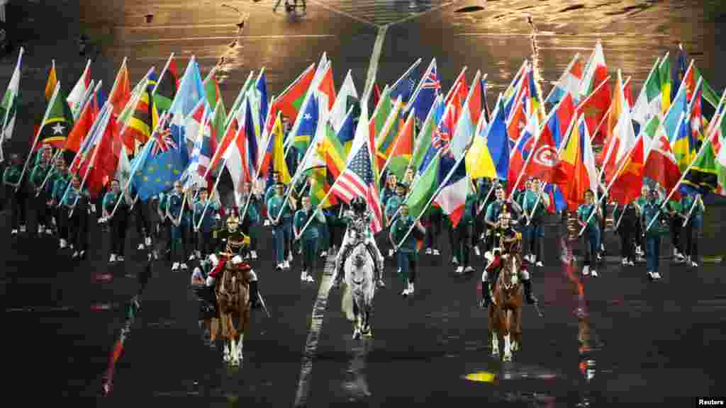 The Olympic flag is carried into the Trocadero by Floriane Issert, center, during the opening ceremony for the Paris 2024 Olympic Summer Games along the Seine, July 26, 2024. (Rob Schumacher/USA Today Sports)