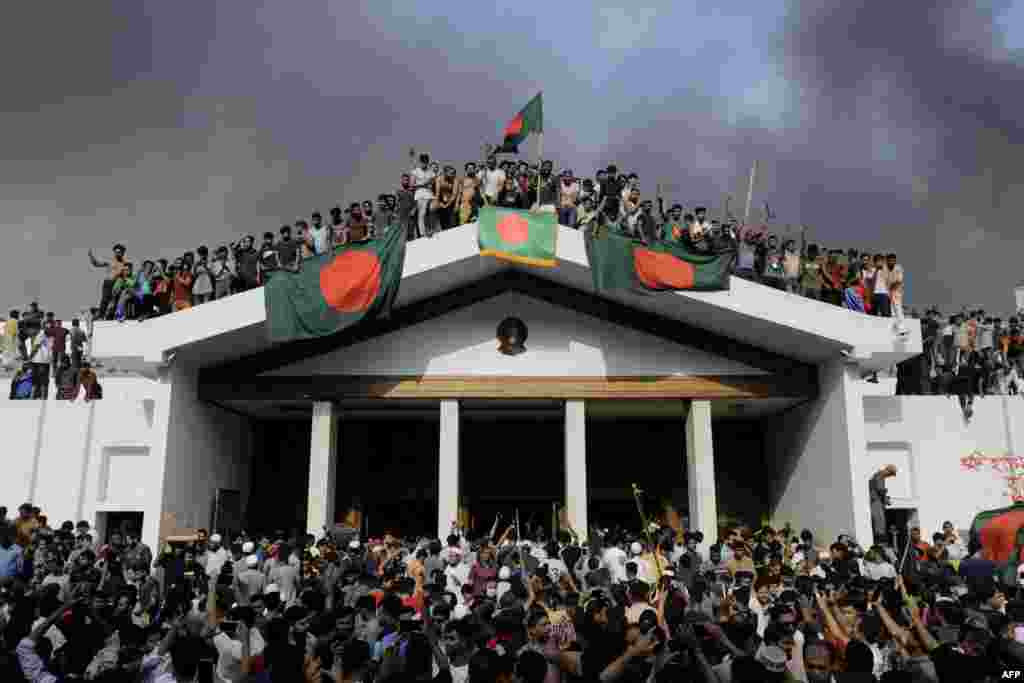 Anti-government protesters display Bangladesh&#39;s national flag as they storm Prime Minister Sheikh Hasina&#39;s palace in Dhaka, Aug. 5, 2024.