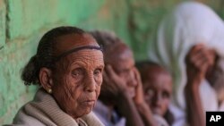 ሰኞ፣ የካቲት 18፣ 2016 ዓ.ም. አንዲት እናት፣ በሰሜን ኢትዮጵያ፣ ትግራይ ክልል በሚገኘው ፊናርዋ ከተማ፣ የወረዳው ዋና ፅህፈት ቤት ውጪ ተቀምጠው ይታያሉ። በአንድ ወቅት ለምለም የነበረው ሜዳ አሁን ምድረበዳ ሆኗል። ፊታቸው በጭንቀት የተሞላ እናቶችም ልጆቻቸው በምግብ እጦት ሲዳከሙ እርዳታ በማጣት ይመለከታሉ። (አሶስዬትድ ፕሬስ ፎቶ፡ አሚር አማን ኪያሮ)