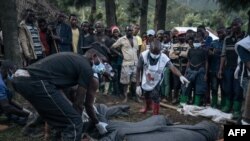 Congolese Red Cross volunteers and residents of Nyamukubi wrap in blankets the bodies of people who died in heavy flooding in eastern Democratic Republic of Congo, May 6, 2023. 