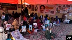 Sejumlah aktivis Baloch memegang foto dari kerabat mereka yang hilang dalam aksi protes di islamabad, Pakistan, pada 25 Desember 2023. (Foto: AP/Anjum Naveed)