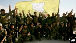FILE - U.S.-backed Syrian Democratic Forces fighters pose for a photo in Baghouz, Syria, March 23, 2019. Violence between the SDF and one of its affiliates in the eastern province of Deir al-Zour erupted on Aug. 28, 2023.