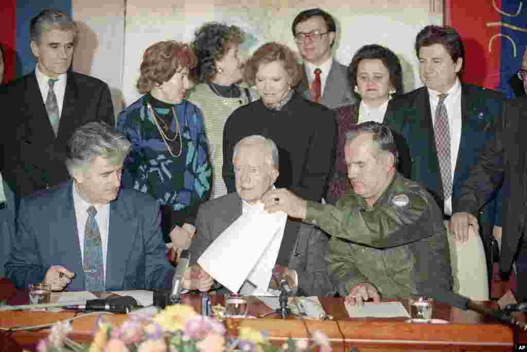 After seven hours of talks at the Bosnian Serb headquarters in Pale, Bosnia, former U.S. President Jimmy Carter, center, Bosnia Serb leader Radovan Karadzic, left, and Bosnian Serb army Commander Ratko Mladic, right, signed a declaration proposing a four-month ceasefire in the Bosnian war, Dec. 19, 1994.&nbsp;