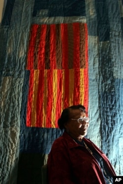 FILE - Quilter Annie Mae Young, of the Gee's Bend area in Alabama, poses in front of her quilt at the Museum of Fine Arts in Boston, May 31, 2005.