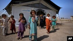 Flood victims leave a school set up in a tent, caused by last year's floods, in Arzi Naich village in Dada, a district of Pakistan's Sindh province, May 17, 2023.