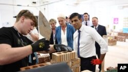 FILE - Britain's Prime Minister and Conservative Party leader Rishi Sunak, right, visits a bricklaying workshop at Cannock College, in Cannock, central England, May 24, 2024, during a campaign event in the build-up to the U.K. general election on July 4.