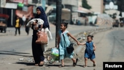 Palestinians flee Rafah after Israeli forces launched a ground and air operation in the eastern part of the southern Gaza City, amid the ongoing conflict between Israel and Hamas, in Rafah, in the southern Gaza Strip, May 15, 2024.