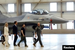 볼로디미르 젤렌스키(오른쪽 두번째) 우크라이나 대통령과 마르크 뤼테(세번째) 네덜란드 총리가 20일 네덜란드 에인트호번 공군 기지를 방문해 F-16 전투기 옆을 지나고 있다.