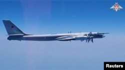 Pembom strategis Tu-95MS dalam penerbangan rutin di atas perairan internasional di Kutub Utara, diambil dari rekaman yang dirilis 14 Agustus 2023. (Kementerian Pertahanan Rusia/Handout via REUTERS)