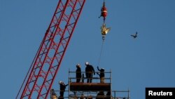 A crane raises the new rooster to install it at the top of the spire of the Notre-Dame de Paris Cathedral, which was ravaged by a fire in 2019 that sent its spire crumbling down, as restoration works continue in Paris, Dec. 16, 2023.