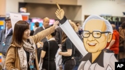 Hami Liu dari Taiwan berpose untuk foto dengan potongan karton Warren Buffett saat Berkshire Bazaar of Bargains di CHI Health Center pada Jumat, 5 Mei 2023. (Chris Machian/Omaha World-Herald via AP)