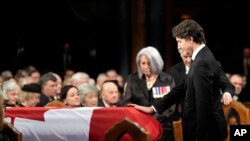 Prime Minister Justin Trudeau places his hand on the casket during the funeral of former prime minister Brian Mulroney, in Montreal, March 23, 2024.