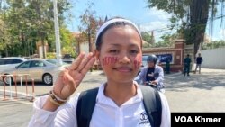 កញ្ញា នុត ធិ សកម្មជនបរិស្ថានឈរលើកដៃបីនៅមុខក្រសួងយុត្តិធម៌ នាព្រឹកថ្ងៃទី ២៦ ខែមេសា ឆ្នាំ២០២៤។ (មាស ដា/វីអូអេ)